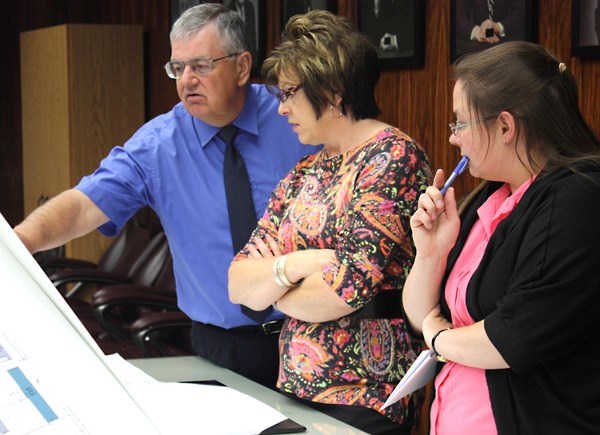 Town CAO Ron Boisvert, receptionist Shannon Halkow and administrative assistant Cindy Litwinski review the plans for the new Wellness Centre to be built east of Canadian Tire 