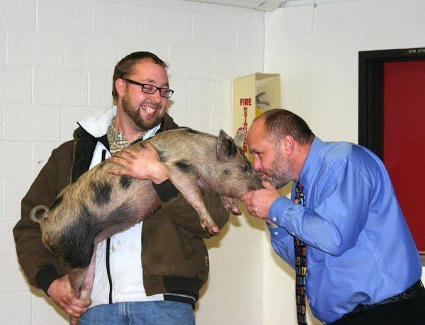 Heinsburg Community School principal Darcy Younghans gives Wilbur the pig a big smooch on Thursday after winning the honour with his fundraising for Haying in the 30&#8217;s. 