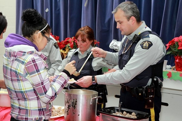 Sgt. Darrell McPherson (right) and Cst. Rowena Shea help serve a Christmas feast at the annual Goodfish Lake community banquet, Dec. 13.