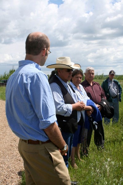 Chief Wallace Fox of Onion Lake Cree Nation speaks about the Frog Lake tragedy, while Alberta Culture&#8217;s Matthew Wangler (left) and other members of the public listen.