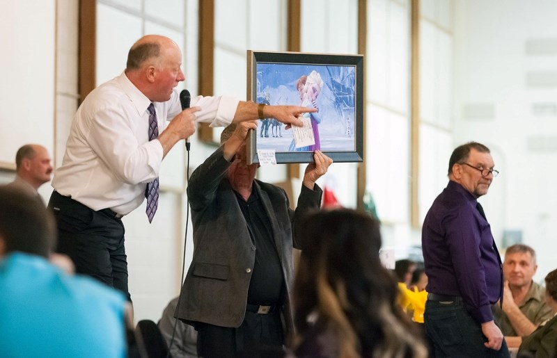 Auctioneer Andy Jubinville brings in bids for a Frozen themed canvas painting that sold for nearly $1,000 at the St. Paul &#038; District Hospital Foundation fundraiser,