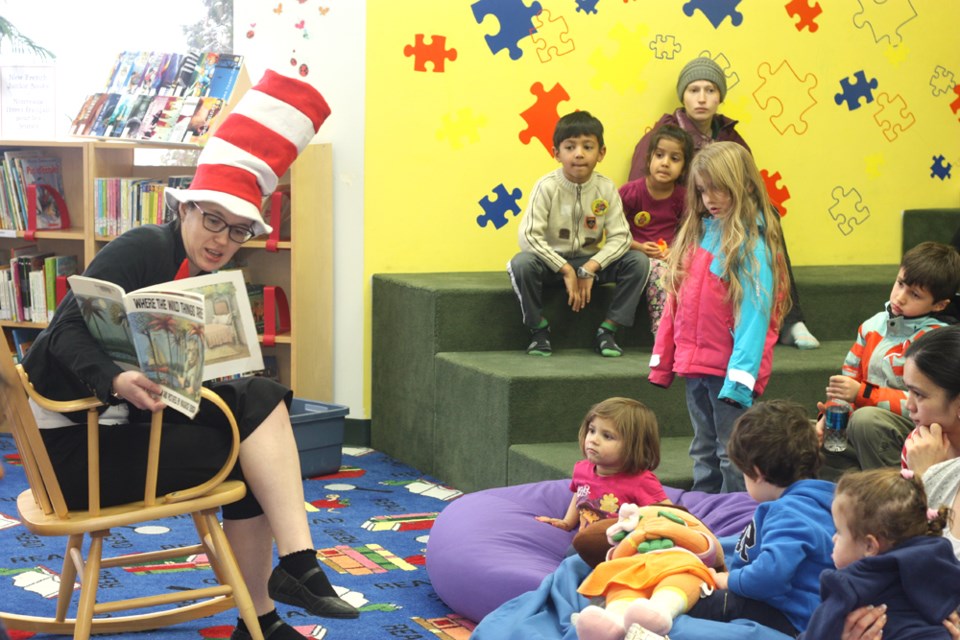 The Cat in the Hat (Meredith Gillis) reads a story to children gathered at the St. Paul Municipal Library last Saturday for Family Literacy Day festivities.