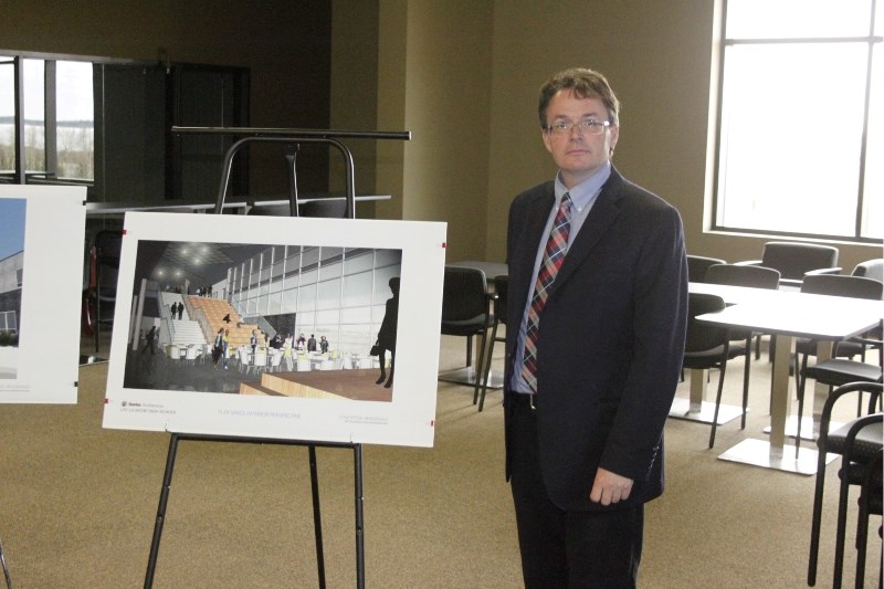 Architect Bill Saul shows off a projected image of the glass &#8220;flux&#8221; space in the new Bold Center high school at a presentation on April 30.