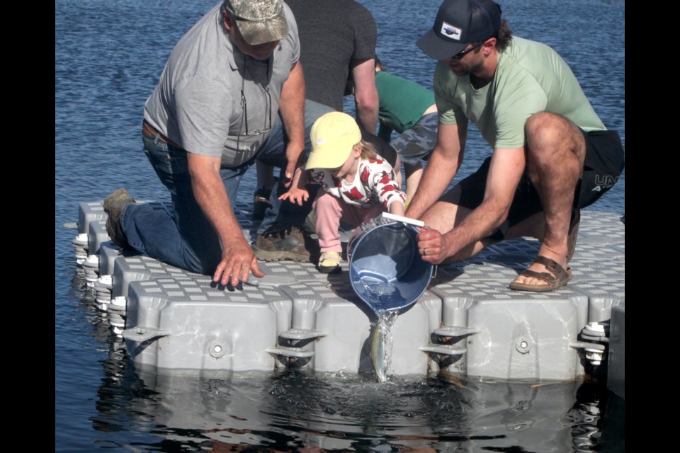 Ivy Wainman gets some help from her grandfather, Randy Vallee, and father, Mitch Wainman, during the family-oriented evening at Alexander Hamilton Park. Chris McGarry photo. 