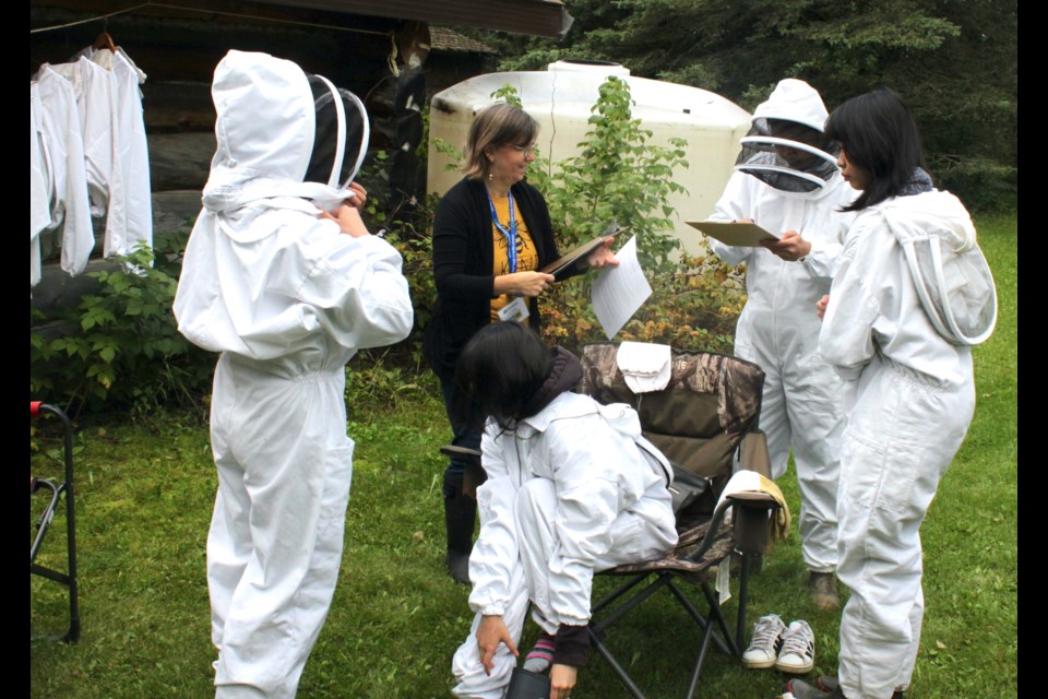 Reggie, Francis, Elyssah, and Allysandra Borces, all of whom are from Edmonton, took advantage of the gorgeous though slightly cool weather on Saturday to visit farms in the Lakeland Region – including Christy Creek Honey in Lac La Biche County – as part of Alberta Open Farm Days. Joanne Wicker, who along with her husband, Rob, operates the honey – producing farm, helps her guests get suited up prior to taking a tour of the beehives. Chris McGarry photo. 