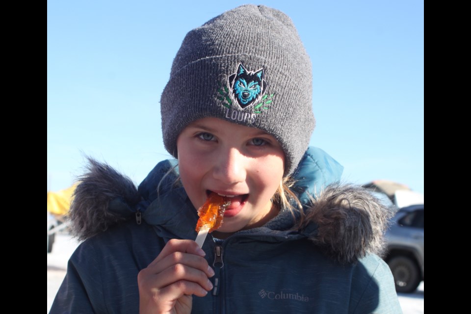 Laiyn Kumpula enjoys some maple syrup taffy at the sugar shack. Chris McGarry photo.