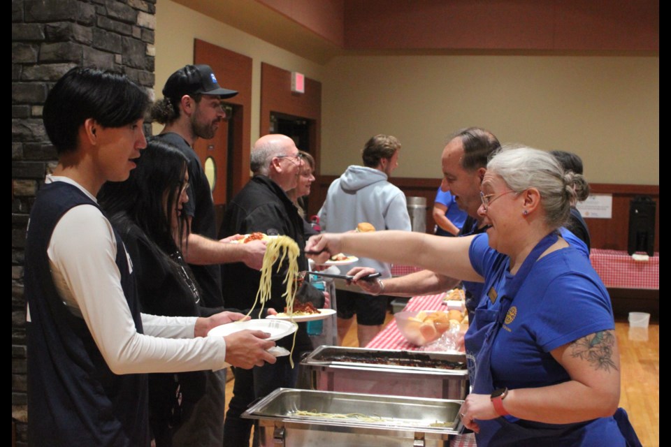 Jen Okrainec, a member of the Rotary Club of Lac La Biche, serves up some pasta to Layne Paul, who stopped into the Bold Centre community hall for the free spaghetti dinner. Chris McGarry photo. 