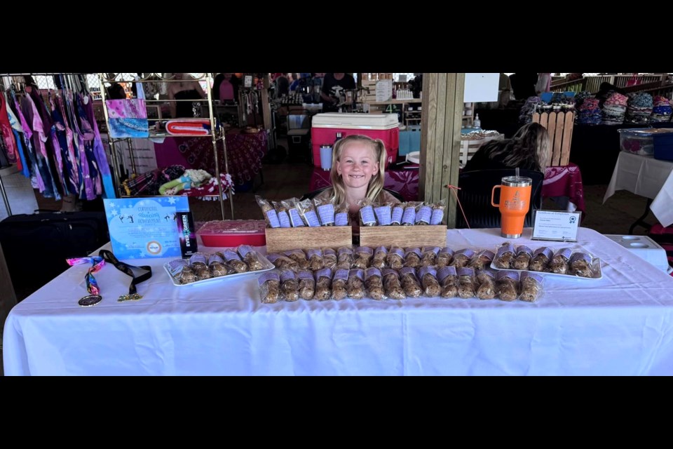 London Miller smiles as she sits her her unique product called Energy Bites at the Lac La BIche Farmer's Market, where she sells them every few weeks. Photo supplied. 