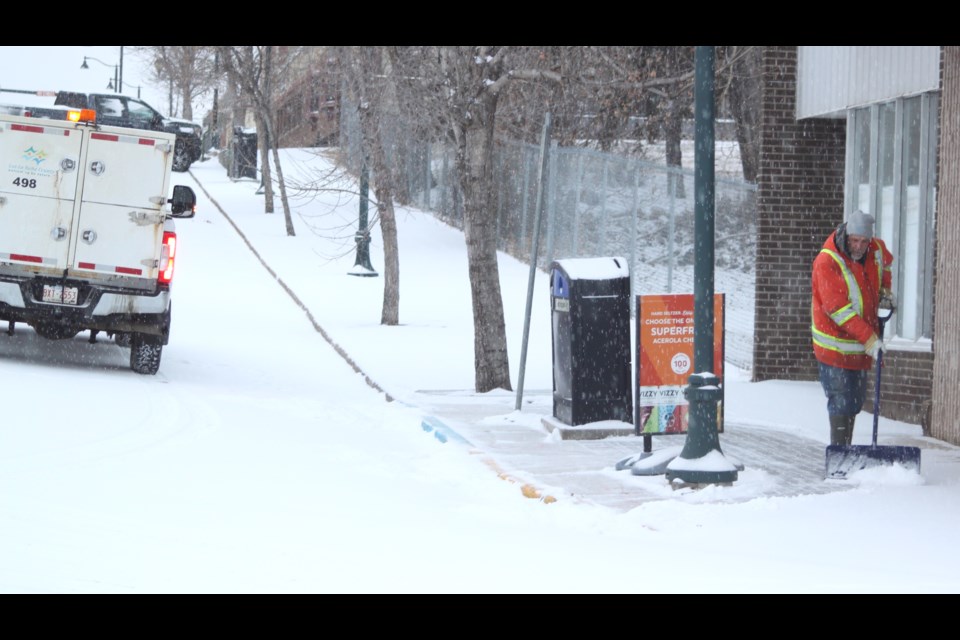 A Lac La Biche County worker cleans snow off of a sidewalk on the corner of 101 Ave. and 100 Street in the hamlet of Lac La Biche on the morning of March 13. Chris McGarry photo. 