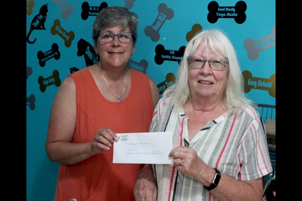 Shirley Michaud, right, receives a cheque for $4,970 from MJ Siebold, vice chair of the Lac La Biche Regional Humane Society board. Michaud is this year's winner of the Humane Society's 50/50 jackpot, which is put on annually as a fundraiser for the local animal shelter. Chris McGarry photo. 