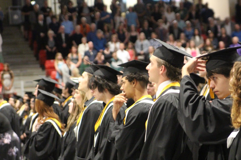 Cold Lake High School graduates in their caps in gowns waiting to receive their diplomas. 