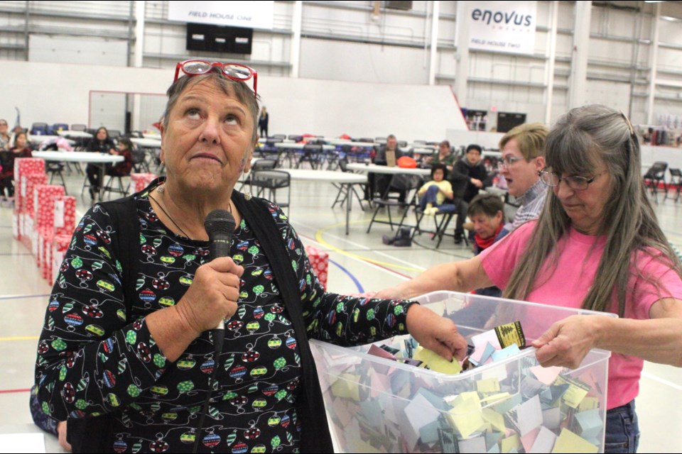 Pat Boon-Anderson isn't looking as she prepares to draw the raffle ticket of a lucky winner at this year's Festival of Trees. Boon-Anderson and organizing team member Carol St. Jean were pulling tickets on Sunday, Nov. 24 at the Bold Center. Chris McGarry photo.