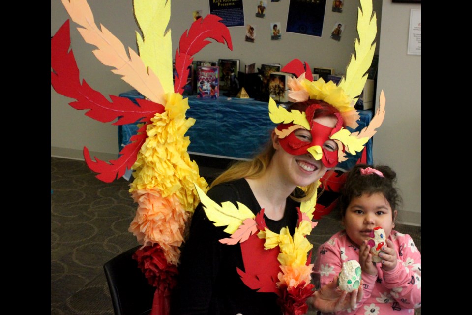 For the 2025 edition of Library Con, Phoenix Murphy took on the persona of her namesake, the immoral bird known within Greek mythology as a phoenix. During the event, Murphy was helping kids such as Kayza Quinn to make dragon’s eggs. Chris McGarry photo. 