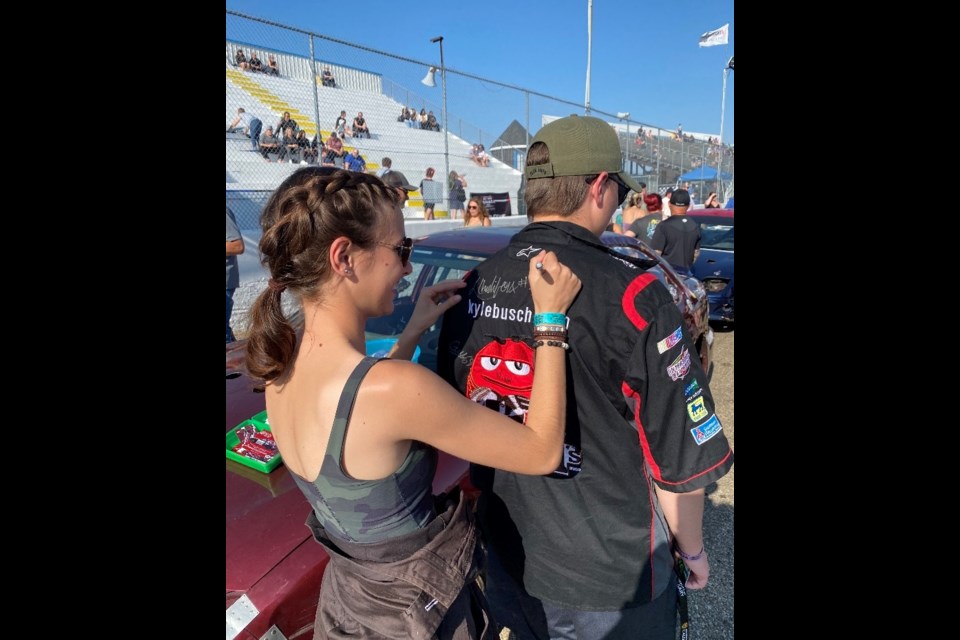 The members of the Teen Social Club in Lac La Biche who recently spent an evening at the Edmonton International Raceway also got to meet the drivers during the event, receive their autographs, but also sign some of their own. Photo supplied. 