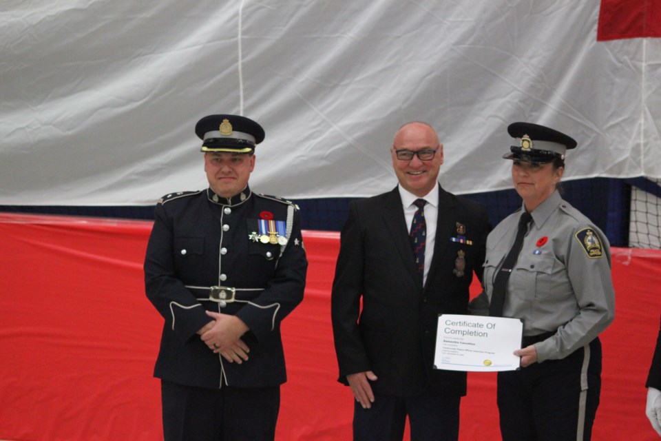 Sam Casselton stands with Chris Clark, director of the Law Enforcement Training Program, and her father, Shaun Casselton, a retired police officer, after she receives her graduation certificate. Chris McGarry photo. 