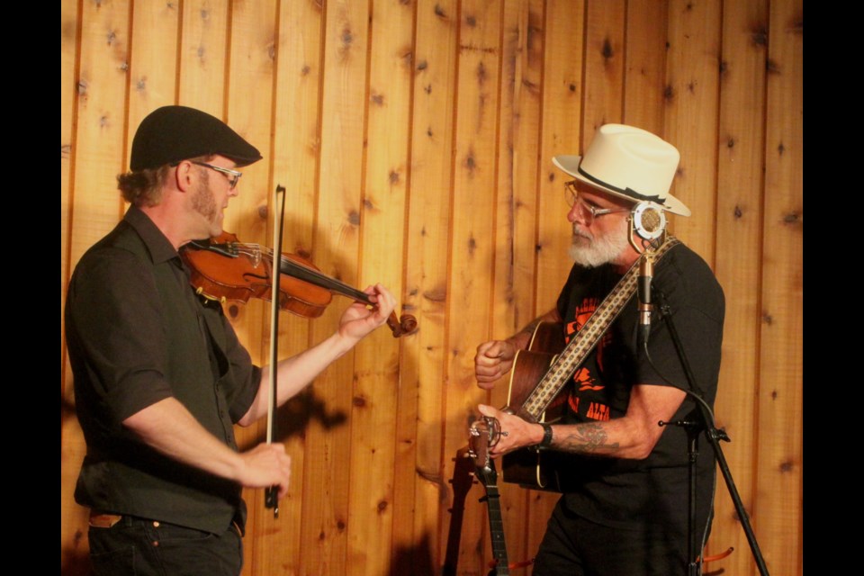 John Wort Hannam, right, brought his style of folksy music to the Sir Winston Churchill campground ampitheatre stage on Saturday, Aug. 17 for the latest concert in the Music in the Forest series. He was accompanied by Calgary-based musician Scott Duncan, who played fiddle during the show. Chris McGarry photo. 