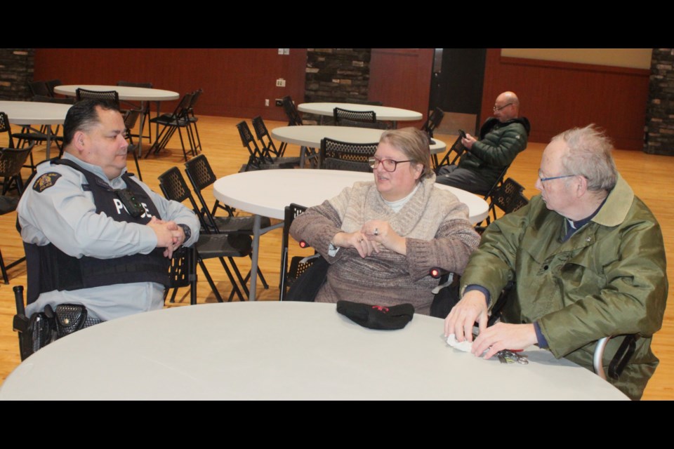 Sgt. Trevor Cardinal, acting commander of the Lac La Biche RCMP detachment, talks with Kevin and Kathryn Pederson, who came to the RCMP town hall at the Bold Centre Community Hall on Feb. 19. The meeting was put on for residents to voice their concerns about crime and other issues in the Lac La Biche area. Chris McGarry photo. 