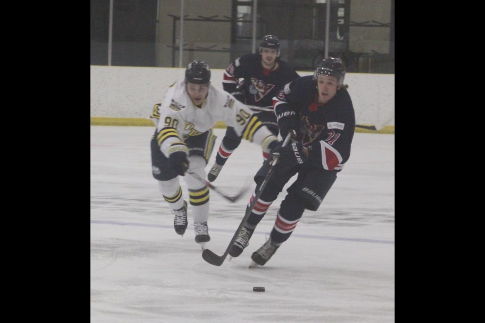 Portage College Voyageurs forward Tye Evans and NAIT OOKs forward Blake Astorino make a run for the puck at the same time during the meeting between the two Alberta Colleges Athletic Conference (ACAC) clubs that took place at Lac La Biche’s Bold Centre on Saturday, Jan. 25. NAIT won the game 6-3. Chris McGarry photo. 