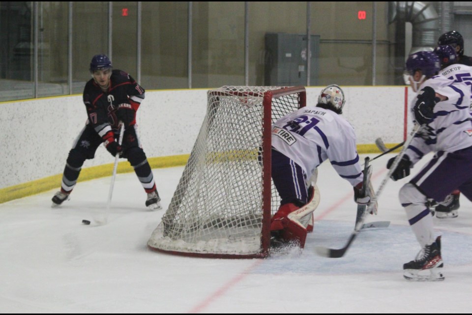 Edson Eagles goaltender Carter Sapach readies himself as Lac La Biche Lakers defenseman Utin Lightning skates around his net with the puck during Saturday's game between the two Northern Junior Hockey League (NJHL) squads at the Bold Center. the Lakers won the contest 6-4. Chris McGarry photo. 