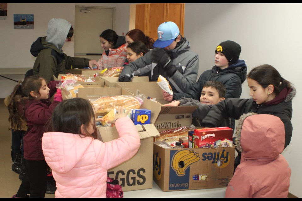 Members of the Lac La Biche Youth Association organizing boxes of food in the basement of the Al Kareem Mosque. Chris McGarry photo. 