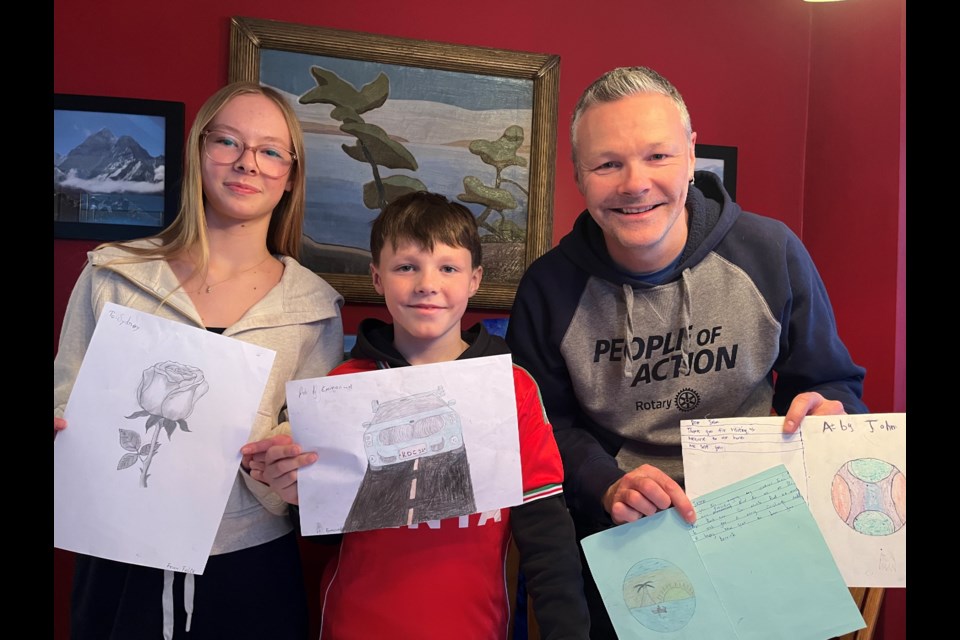 From left, Sydney Wilson, Kyle Wilson, and Jason Wilson returned home from a trip to Kenya with gratitude, displaying images from boys they worked with at a Life4Kids facility.