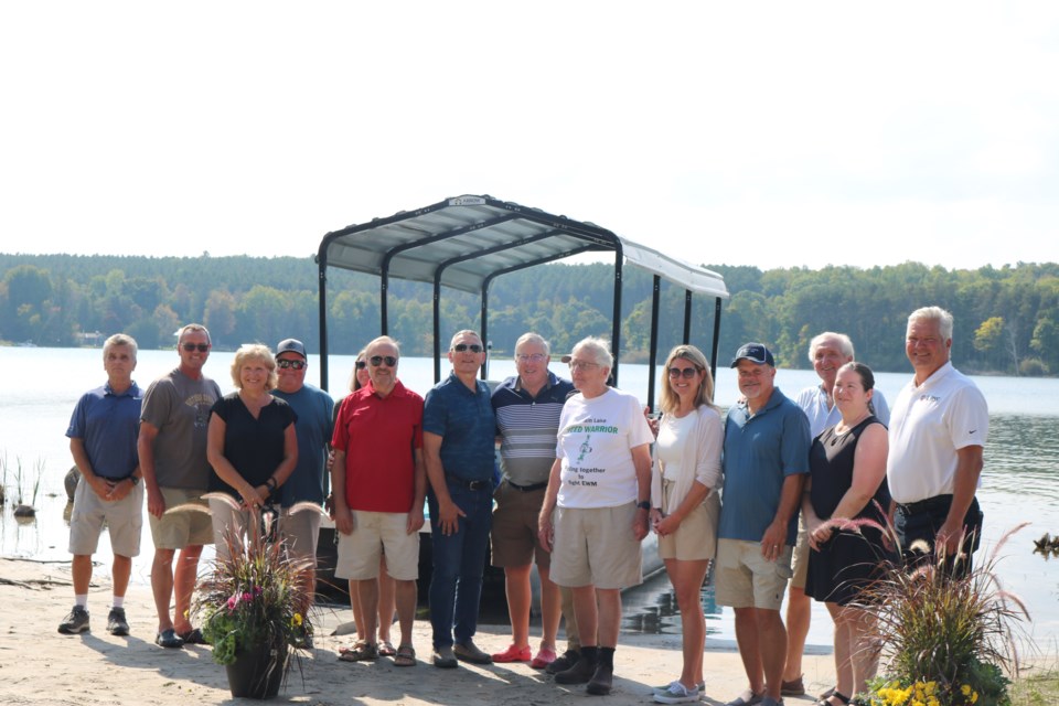 MPP Jill Dunlop in the middle, Tiny Township Mayor Dave Evans on the right, Councillor Dave Brunelle, SSEA Invasive Species Coordinator Patrick Jackson, FLCA President Scott Dales and FLCA volunteers at an event Saturday to mark the positive impact a grant received from the Ontario Trillium Foundation has had on the removal of the invasive species, Eurasian Watermilfoil, from the Farlain Lake