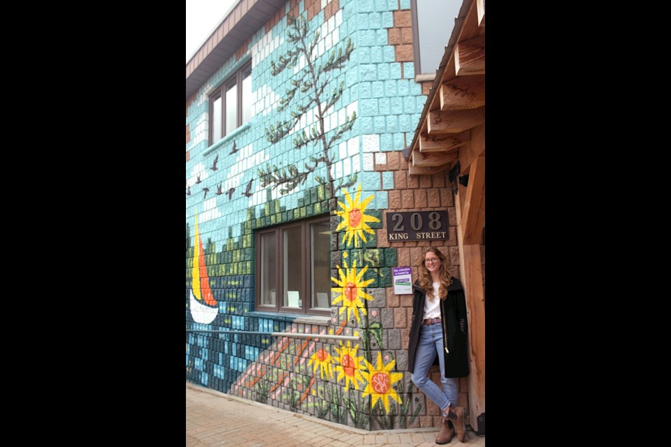 Wasaga Beach artist Shandelle Page McCurdie poses beside her newly unveiled mural in Midland at the Downtown BIA building, having been selected as the artist through the town's ‘Downtown Midland Comes to Life: Arts and Ambiance’ project.