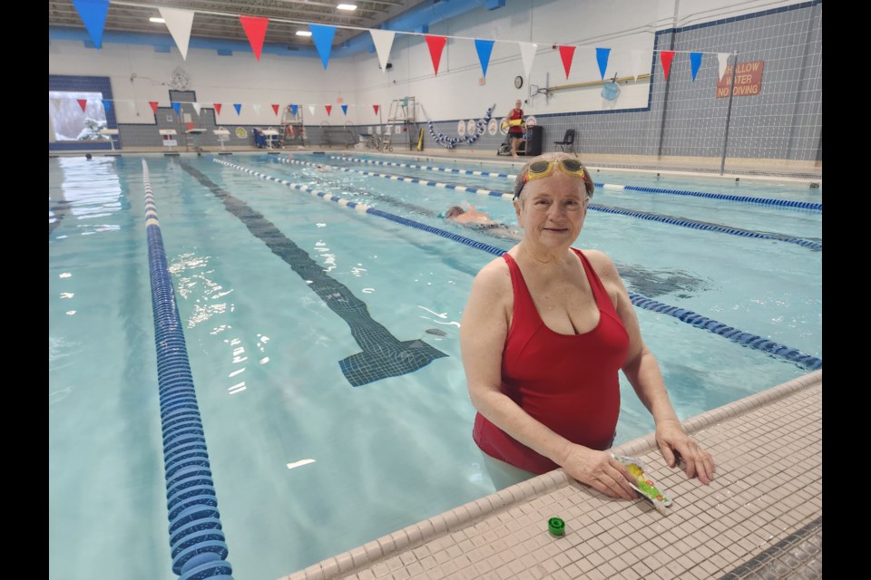 Gwen Crump takes a break during her planned 80-lap swim at Midland's YMCA Friday morning.