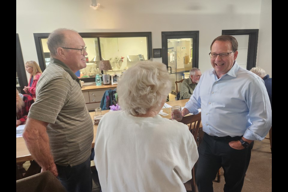 Green Party Leader Mike Schreiner chats with a couple of local residents during a stop in Midland Friday.