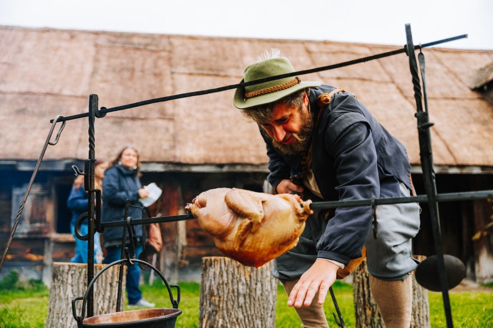 A historical interpreter roasts a duck over a fire at Sainte-Marie among the Hurons’ Hometown Harvest Festival.