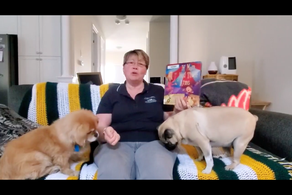 Linda Keenan, CEO of Penetanguishene Library, reads a bedtime story to her dogs. Supplied photo.