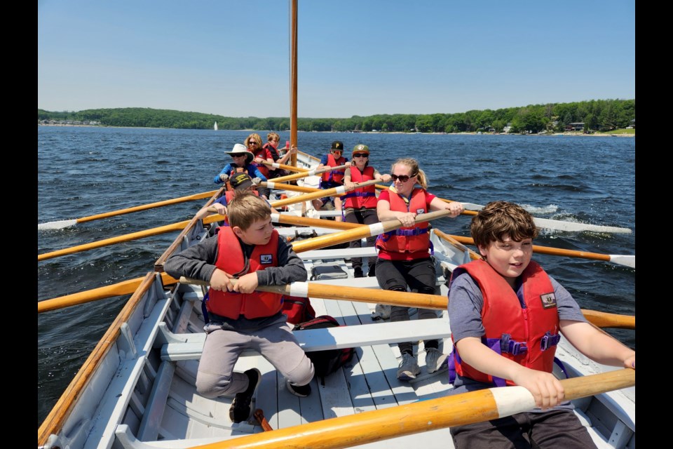 Youth from the Midland area are seen rowing a wooden replica longboat on Georgian Bay last summer. 