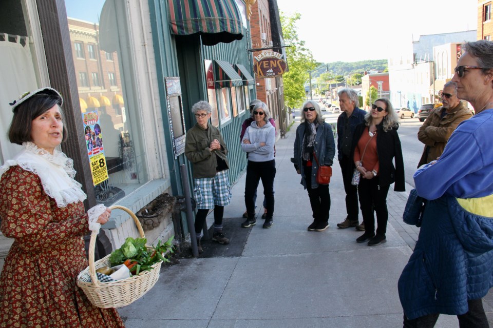 Historical interpreter Irene Lau talks to the group attending the first Penetanguishene Downtown Historical Walking Tour of the summer about the Beck Block on Main Street.