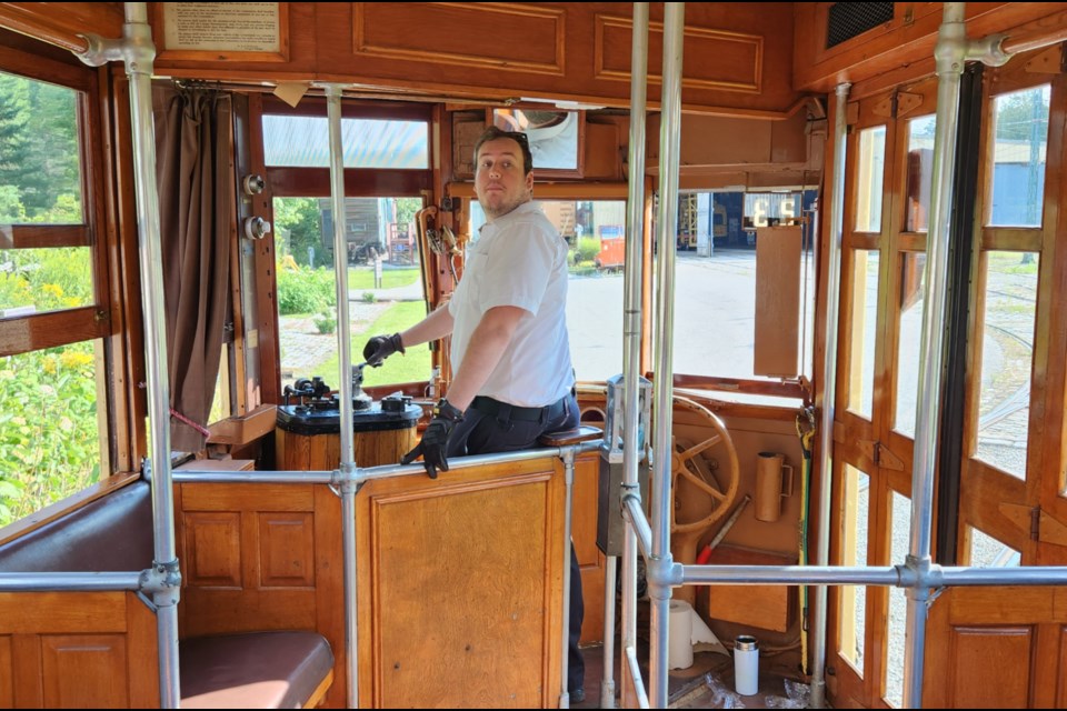 A volunteer drives the streetcar for people to enjoy for the day.