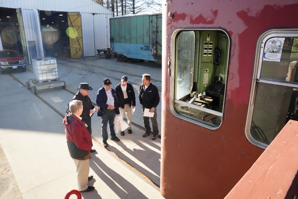 Several train enthusiasts, including Railway Museum President Bob Lubinski (second from left) discuss the Red Rocket.