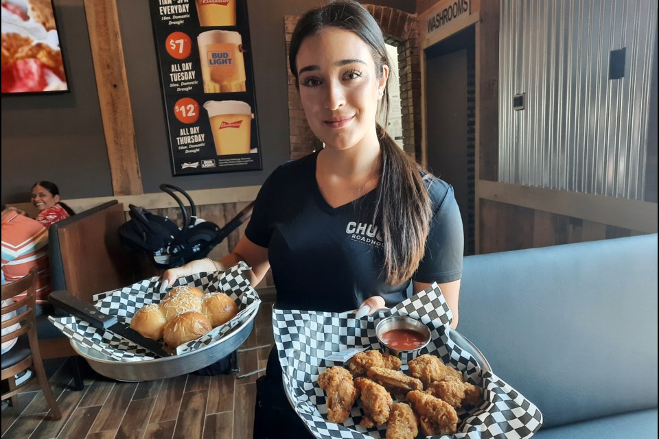 Ashante Camara serves up some appetizers during the opening of Chuck's Roadhouse.