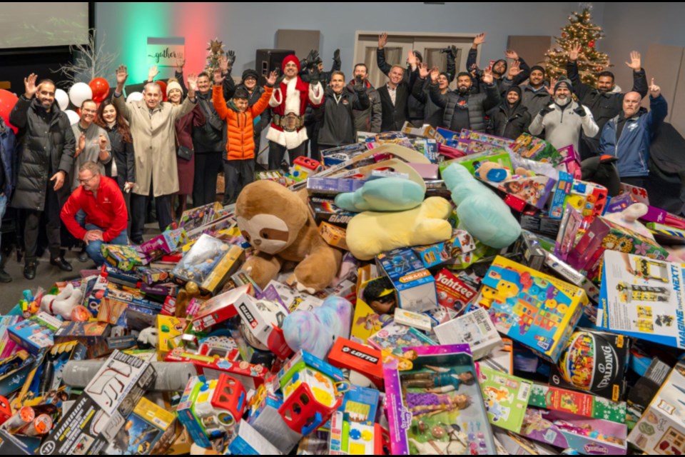 Tiger Jeet Singh Jr. joins with supporters to celebrate the mountain of toys donated to Miracle on Main Street.