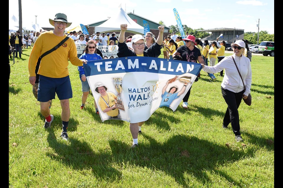 Allan McNeill, centre, is joined by his brother and sister as they lead Team Allan out onto the route for the Halton Walk for Down Syndrome. The team from Burlington was the top fundraiser at the event held at the Milton Fairgrounds, that attracted over 600 walkers from across Halton.