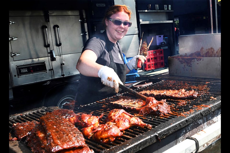 Tia Howe of Louisiana Bar-B-Que, the ribber has fun as she slathers on the sauce, while grilling racks of ribs at the Milton Rib and Beer Fest.