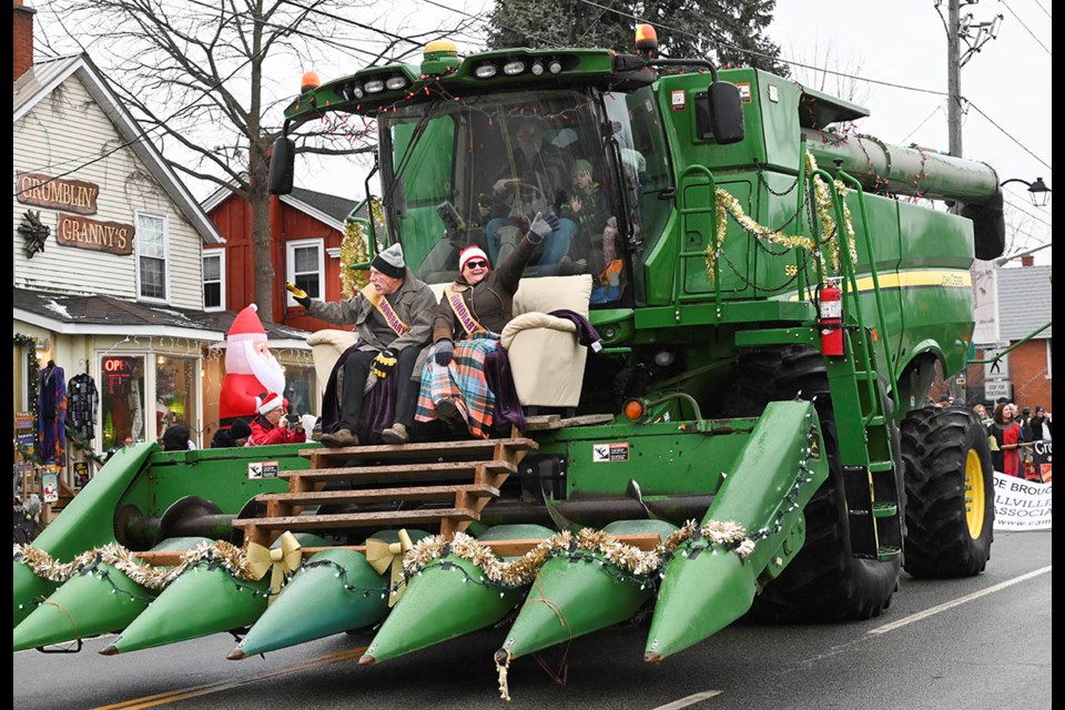 Campbellville Honorary Mayors Peter and Liz Lamarck wave from their couch atop a farm combine to help kick off the 50th annual Campbellville Santa Claus Parade Sunday.