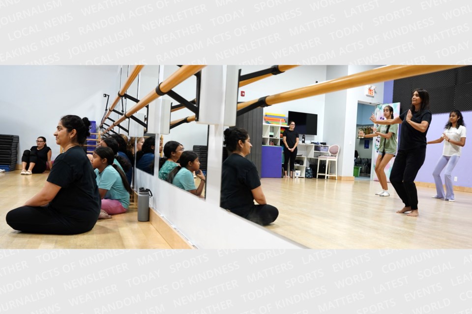 Deepti Penkar (sitting) watches Vandana Majithia lead her students in a dance routine.