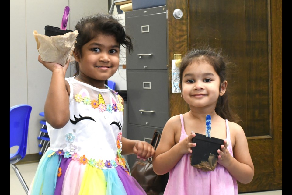 Eliana (left) and Avery (right) show their new plants following the Fun with Food and Farming event on Aug. 13.