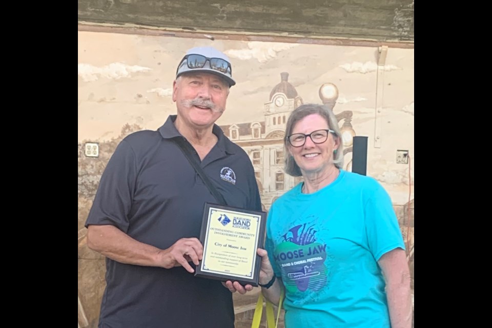 Moose Jaw Mayor Clive Tolley receiving an award from the Saskatchewan Band Association, presented by Janie Fries. The award is for Moose Jaw’s role in hosting the festival for over 70 years