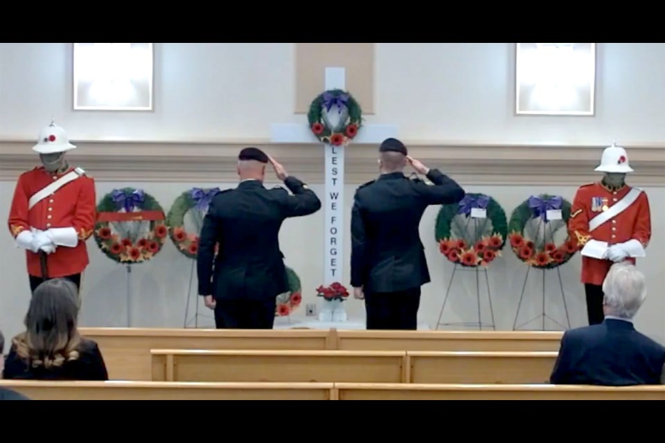 The Saskatchewan Dragoons salute the cross and wreaths in the Moose Jaw Funeral Home. Facebook screencap