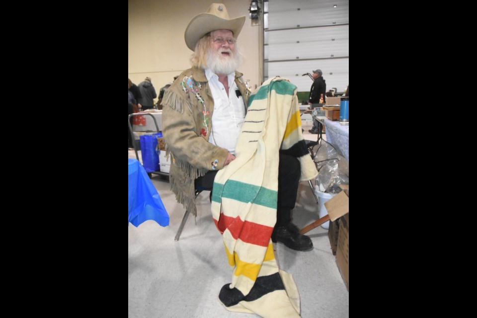 George Chopping displays a 1920s Hudson Bay Trapper Point blanket he found at the antique show. Photo by Jason G. Antonio