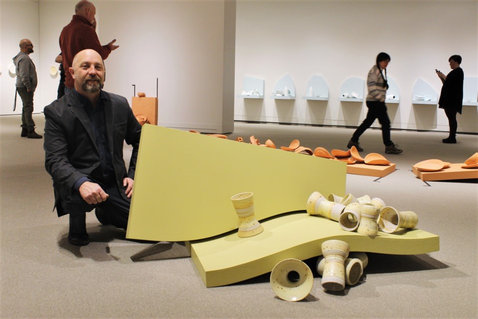 Artist Robert Froese, posing with his piece “Reassembled,” during the opening of exhibition Measured Composition at the Moose Jaw Museum & Art Gallery.