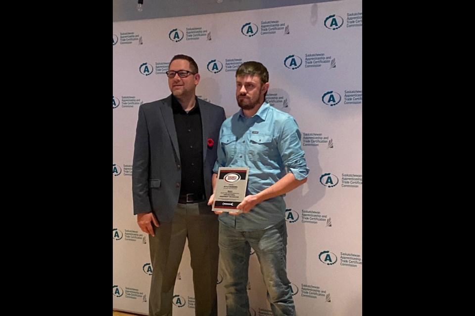 Joel Rasmussen presents Kyle Robbins (r) with his scholarship award. 