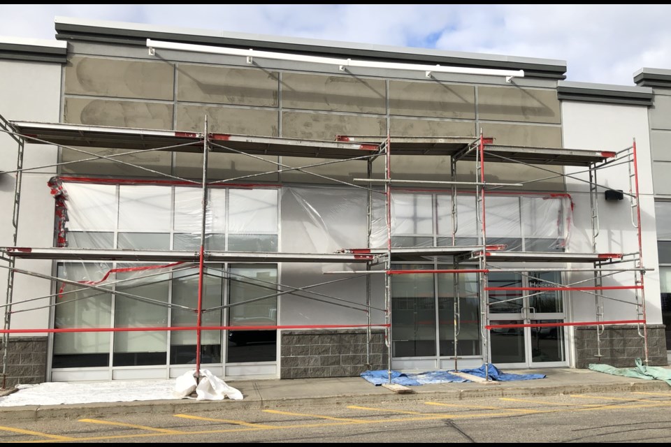 Scaffolding covers the entrance to Henderson Insurance as the company installs new signs as part of its amalgamation with two other insurance brokerages. Photo by Jason G. Antonio