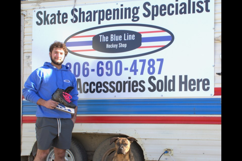 Kolter Mealing stands next to his loyal companion, Spuds, in front of The Blue Line Hockey Shop on the morning of Oct. 26.