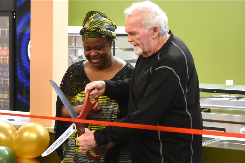 Temitope Adewumi (left), owner of the Coral Kitchen, waits with anticipation to cut the ribbon announcing the restaurant’s grand opening alongside Rob Clark (right), CEO of the Moose Jaw & District Chamber of Commerce at the Town ‘N’ Country Mall on Jan. 25.